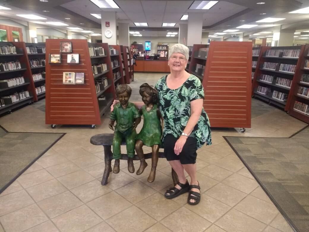 Member-at-Large Beth Cottrell served as President for several years and volunteered many hours to the Friends. She donated the statue that sits at the entrance of the Library in memory of her husband Noland Cottrell.